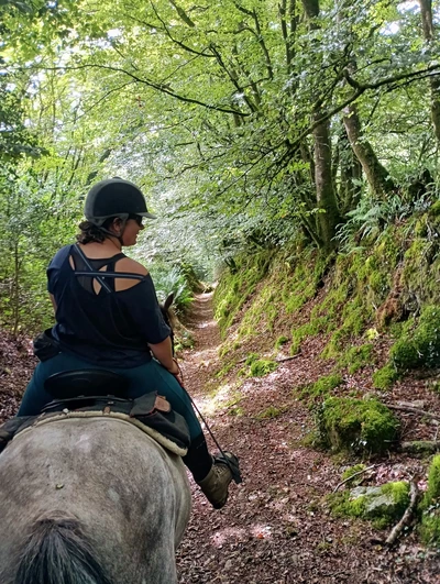 Femme à cheval dans un chemin creux en Bretagne